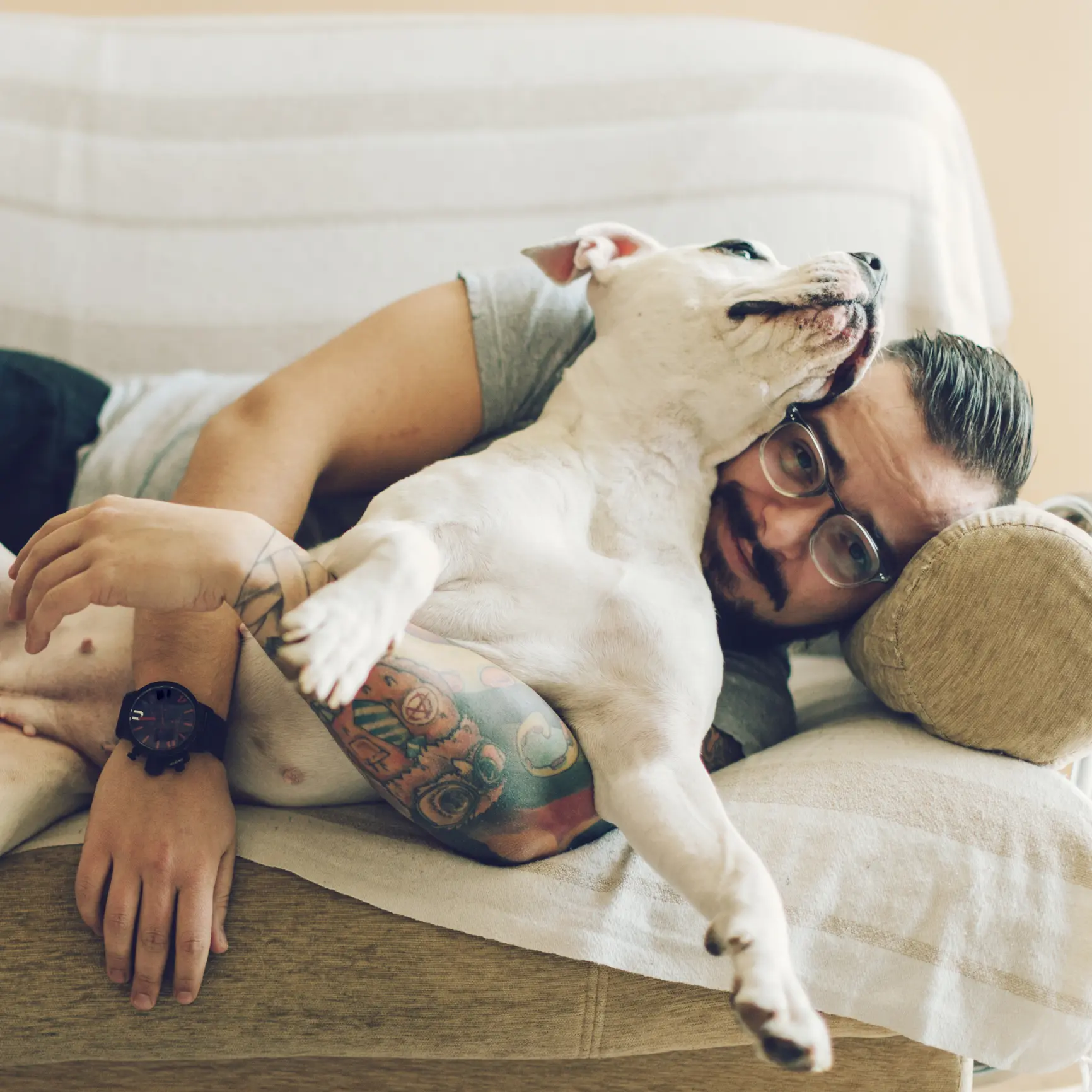 Man with tattoo embracing his dog. Pet memoriam services in Virginia